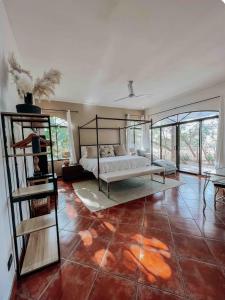 a bedroom with a bed in a room with red tile floors at Hacienda La Luna Luxury Private Villa in Potrero