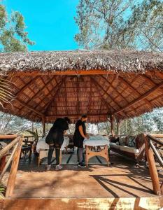 two people standing under a thatched roof at Hacienda La Luna Luxury Private Villa in Potrero