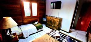 a bedroom with a bed and a television in it at Wooden House in Maria da Fé