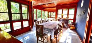 a dining room with a table and some windows at Wooden House in Maria da Fé