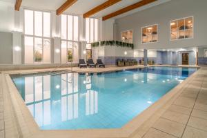 a large swimming pool with blue water in a building at Daresbury Park Hotel in Daresbury