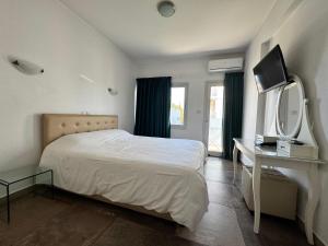 a bedroom with a bed and a mirror and a dresser at Vega Apartments in Limassol