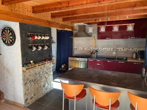 Master Bedroom - Verbier Chalet في فيربير: مطبخ بخزائن حمراء وكراسي برتقالية