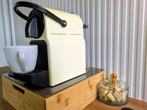 a coffee maker on a wooden stand with a cup at Yutz and Zen in Basse-Yutz
