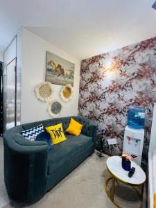 een woonkamer met een groene bank en een muur bij adtek homes Room PENDO in Nairobi