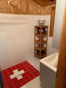 Master Bedroom - Verbier Chalet في فيربير: حمام مع حوض استحمام أبيض وأرضية من البلاط الأحمر