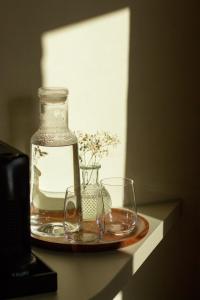 达默De Snippe的桌子上放着一个盘子，盘子里有两个玻璃杯和一个花瓶。