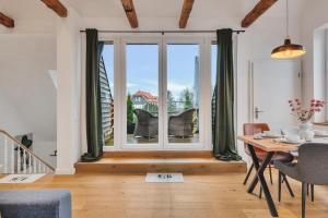 a dining room with a table and a large window at Novita apartment 2 - central - balcony - mountain views in Bad Harzburg