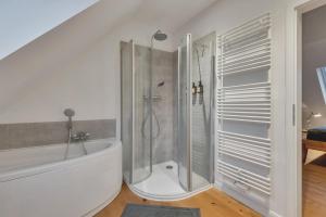 a white bathroom with a shower and a tub at Novita apartment 2 - central - balcony - mountain views in Bad Harzburg +36 photos