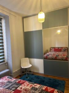 a bedroom with two beds and a white chair at Séjour entre ville et montagnes Appartement 90 m2 in Thann