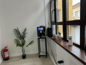 Zimmer mit einem Tisch, einem TV und einem Fenster in der Unterkunft Uniri Urban Escape 103 in Craiova