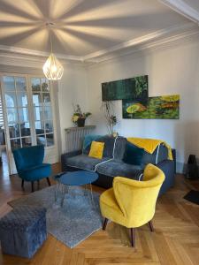 a living room with a blue couch and chairs at Séjour entre ville et montagnes Appartement 90 m2 in Thann +2 photos