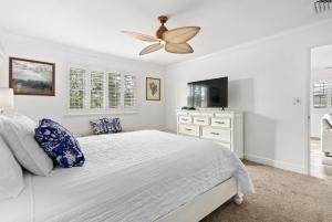 a white bedroom with a bed and a ceiling fan at Island Paradise Resort Villa in Honokai Hale
