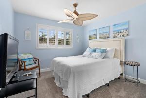 a bedroom with a bed and a ceiling fan at Island Paradise Resort Villa in Honokai Hale