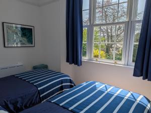 a bedroom with two beds and a window at Rose Court Holiday Apartments in Torquay