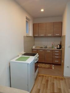 a kitchen with a white refrigerator and wooden cabinets at Daily rental apartment Travnik in Travnik