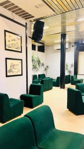 een wachtkamer met groene stoelen en een flatscreen-tv bij Zeeva Hotel and Resort in Torre Dei Corsari
