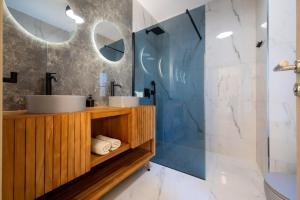 Un baño con dos lavabos y una ducha de cristal. en Imperium Nova, en Nairobi