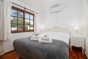 una camera da letto con un letto con due asciugamani sopra di Villa Kunterbunt Punta del Este a Punta del Este