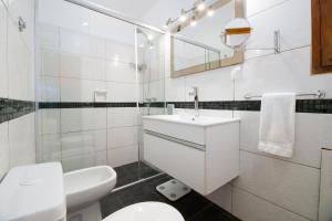 un bagno bianco con lavandino e WC di Villa Kunterbunt Punta del Este a Punta del Este