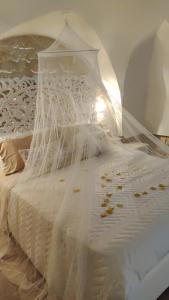 a white bed with a net on top of it at Victoria's Home in Faccia di Trippa +24 photos