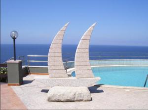 een standbeeld naast een zwembad met uitzicht op de oceaan bij Zeeva Hotel and Resort in Torre Dei Corsari +80 foto's