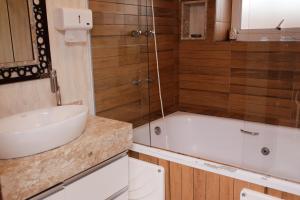 a bathroom with a sink and a bath tub at Castelinho Solemar - Suíte Premium com Banheira Privativa e Ar in Praia Grande +8 photos