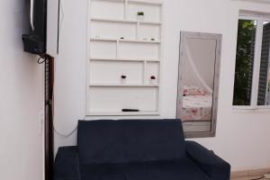 a living room with a blue couch and a mirror at Castelinho Solemar - Suíte Premium com Banheira Privativa e Ar in Praia Grande