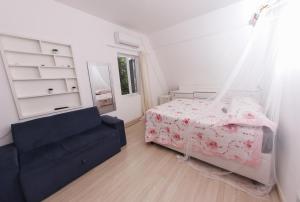 a bedroom with a bed and a chair in it at Castelinho Solemar - Suíte Premium com Banheira Privativa e Ar in Praia Grande