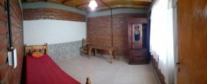 una stanza con un tavolo rosso e un muro di mattoni di La comarca hostel a San Luis