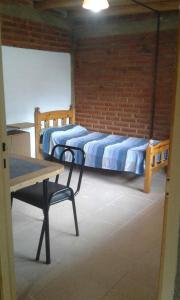 2 letti in una camera con tavolo e scrivania di La comarca hostel a San Luis