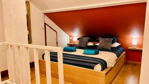 a bedroom with a large bed with blue pillows at L'Escale de Pontcarré - Disneyland Paris in Pontcarré