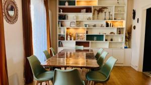 a dining room with a table and green chairs at L'Escale de Pontcarré - Disneyland Paris in Pontcarré