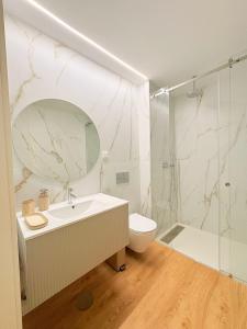 a bathroom with a sink and a toilet and a shower at New Douro Tower 206 with shared pool in Vila Nova de Gaia +18 photos