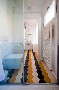 een badkamer met een blauw toilet en een geel-zwarte vloer bij Mimi Carera Apartment & Room in Rovinj