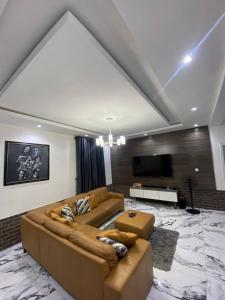 ein Wohnzimmer mit einem großen Sofa und einem Flachbild-TV in der Unterkunft Elite Luxe in Lekki + 7 Fotos