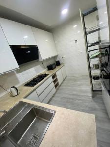 eine Küche mit weißen Schränken und einem Waschbecken in der Unterkunft Elite Luxe in Lekki