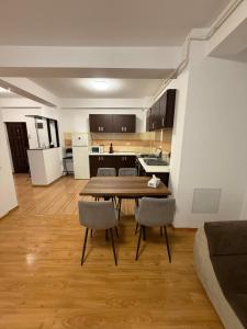 a kitchen and dining room with a table and chairs at Comfort Stay Apartment - Free Parking & Wi-Fi in Chiajna
