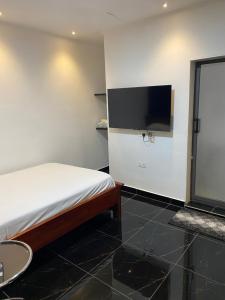 a bedroom with a bed and a flat screen tv at Ma Passion in Accra