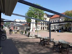 Un patio con mesas y sillas en una plaza del pueblo. en Apartman Čeliković, en Bosanski Šamac 29 fotos más