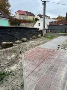 ceglana ścieżka na podwórku z domami w tle w obiekcie Suterénní byt na Hejtmánce v Mladé Boleslavi u letiště w mieście Mladá Boleslav