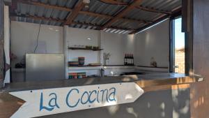eine Küche mit einem Schild, auf dem „la cena“ steht in der Unterkunft La Window Glamping in La Ventana