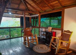 a room with two chairs and a table and windows at Ecohotel Alflo Inn in Villeta