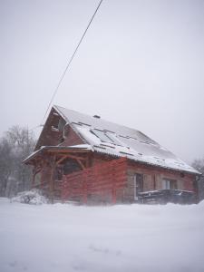 科雷尼察Plitvički San的屋顶上有雪的小木屋