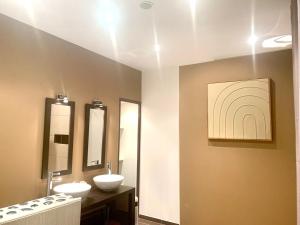 ein Badezimmer mit zwei Waschbecken und zwei Spiegeln in der Unterkunft Siena- Maison 6 personnes proche Luxembourg in Longlaville
