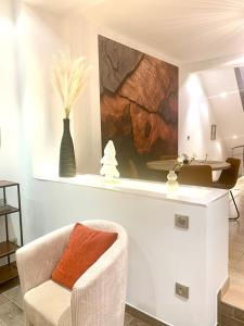 ein Wohnzimmer mit einem Stuhl und einem Tisch in der Unterkunft Siena- Maison 6 personnes proche Luxembourg in Longlaville