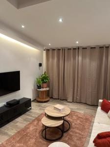 ein Wohnzimmer mit einer Couch, einem Fernseher und einem Tisch in der Unterkunft Siena- Maison 6 personnes proche Luxembourg in Longlaville