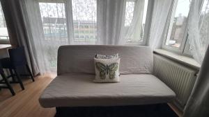 a chair with a pillow on it in a room with windows at Apartament Leśny Ząbki in Ząbki +17 photos