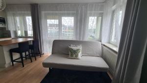a chair with a pillow on it in a room with windows at Apartament Leśny Ząbki in Ząbki