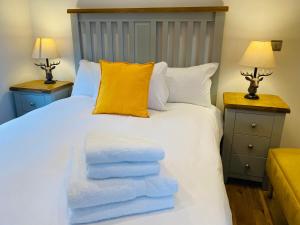a bedroom with a white bed with towels on it at Luxury Portree Cottage Hillside in Portree